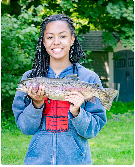 young girl holding a rainbow trout