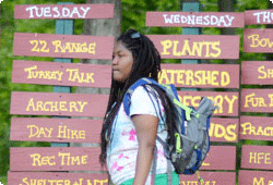 woman walking in front of GMCC activity signs