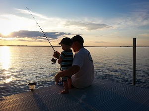 father and son on a dock fishing