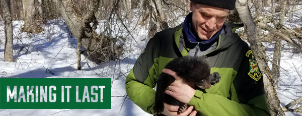 Fish and Wildlife staff with a bear cub