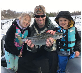 father with 2 daughters and nice salmon