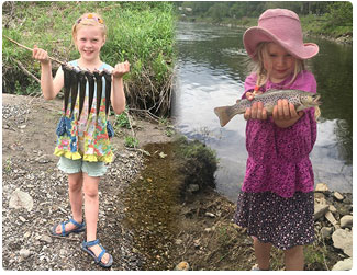 two young girls proudly showing off their catch