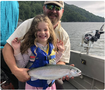 Dad and daughter show off their fine catch of a steelhead trout.