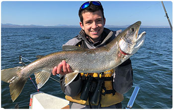 Angler on a boat with a nice lake trout