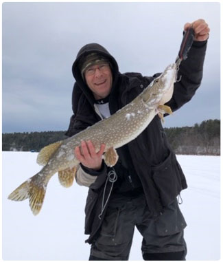 angler with a nice pike caught through the ice