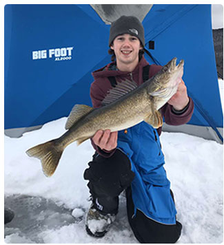 angler with a walleye caught through the ice