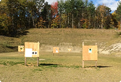 Shooting targets in an open field with a berm in the background