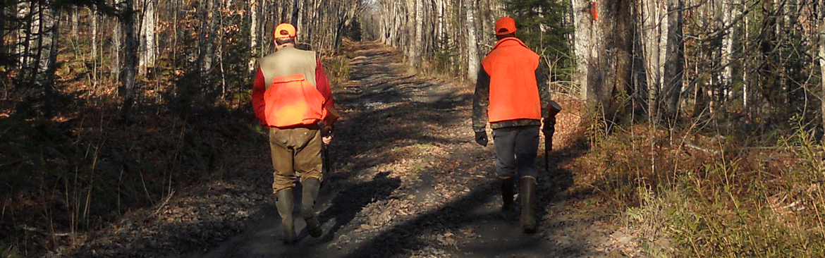 two hunter walking on road in woods