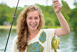 girl with a sunfish on a fishing line