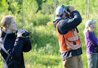 Three wildlife viewers with binoculars