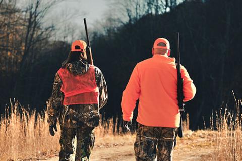 man and a women hunting wearing orange