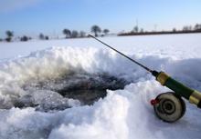 drilled ice fishing hole and rod
