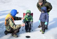 Father and kids get instruction on ice fishing